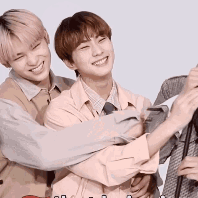 two young men are hugging each other and smiling for a photo