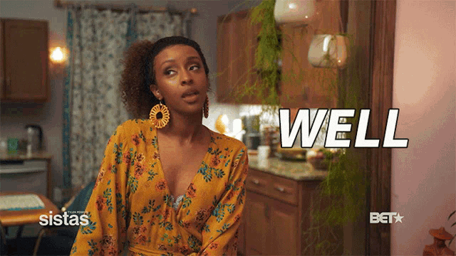 a woman in a yellow floral dress says well in a kitchen