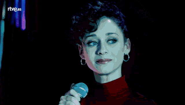 a woman singing into a microphone with the letters rtve.es behind her