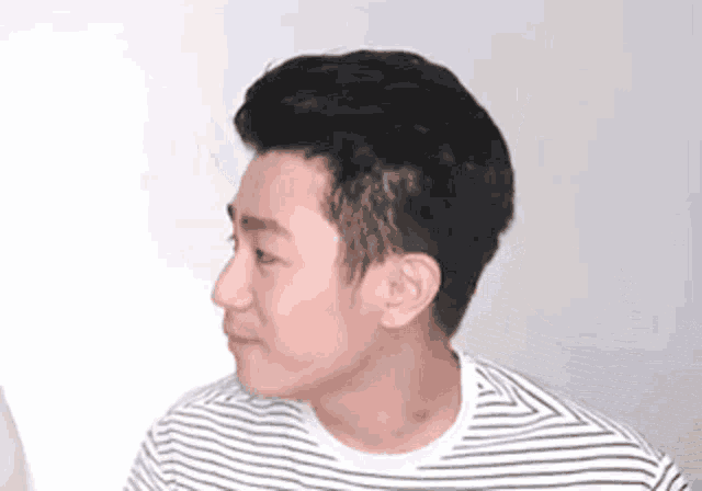 a man wearing a striped shirt is looking at something .