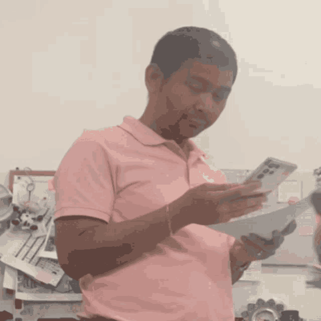 a man in a pink shirt is holding a remote control
