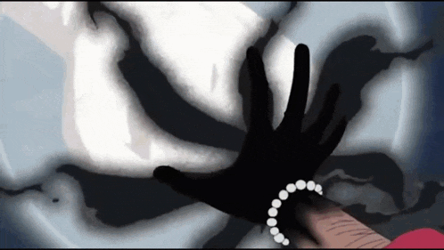 a hand with a pearl bracelet is reaching out towards a ghost .