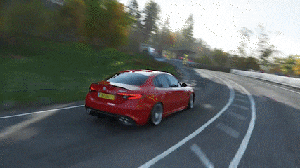 a red car is driving down a curvy road with a license plate that says ' rc ' on it
