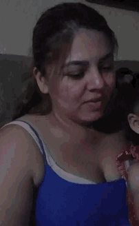 a woman in a blue tank top is talking to someone