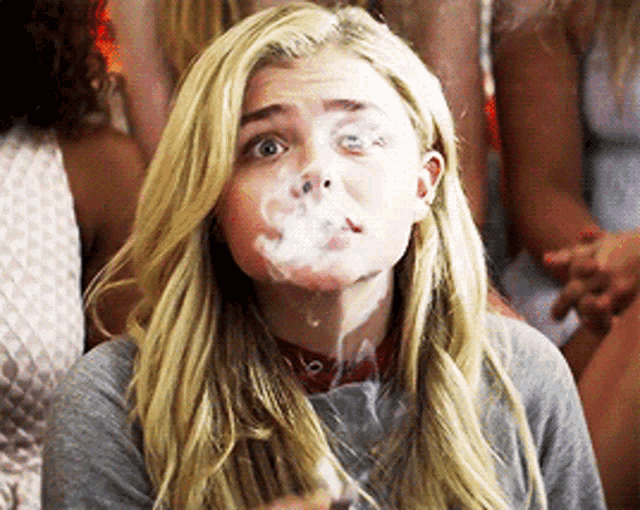 a woman with a lot of smoke coming out of her mouth .