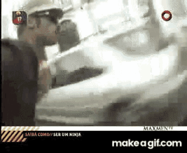 a man in a hard hat is kissing another man in front of a white car