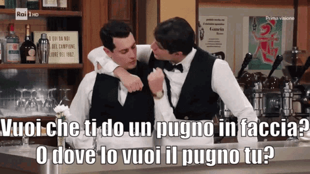 two men hugging in front of a sign that says prima visione