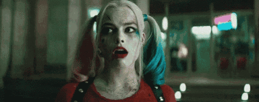 a close up of a woman in a harley quinn costume with pigtails .