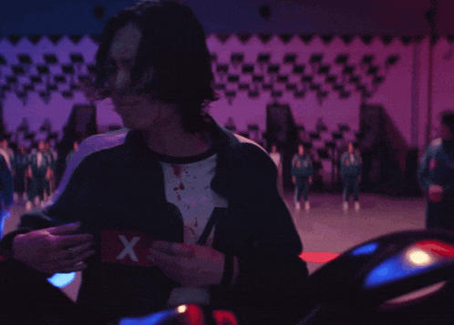 a group of people are standing in a gym with a checkered wall