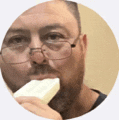 a man wearing glasses is eating a piece of soap