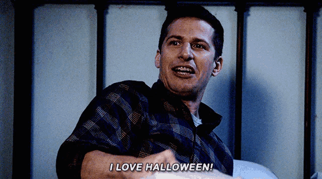 a man in a plaid shirt is sitting on a bed saying i love halloween