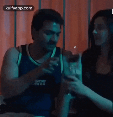 a man and a woman are sitting at a table with glasses of wine .