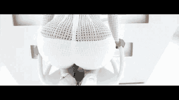 a woman in a white dress is sitting on a white chair with her butt showing .
