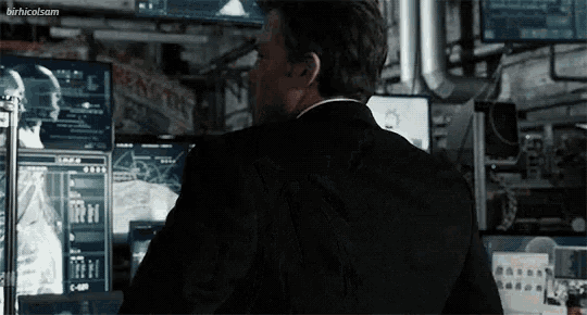 a man in a suit is standing in front of a computer screen with the words birthcatsam on the bottom right