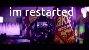 a person is holding a bag of chips in front of a camera and the words im restarted are on the screen