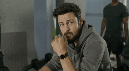 a man with a beard wearing a watch that says 10:08