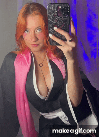a woman with red hair is taking a selfie with her phone