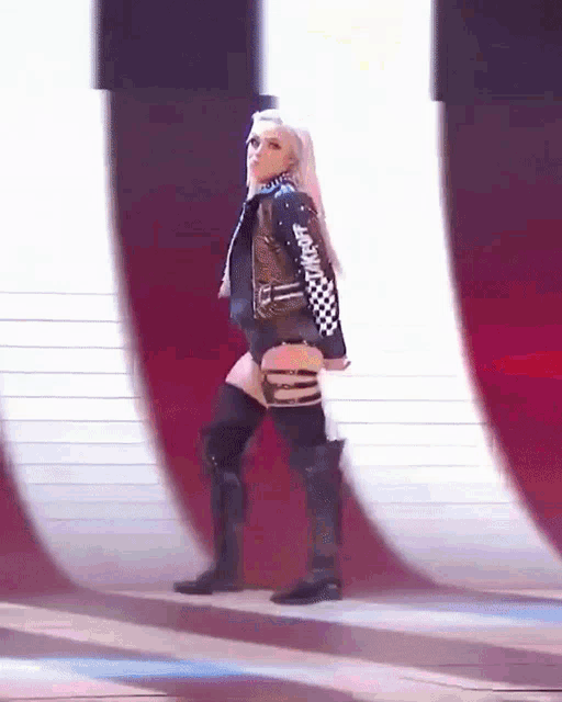 a woman in a black and white checkered jacket is walking on a red and white background