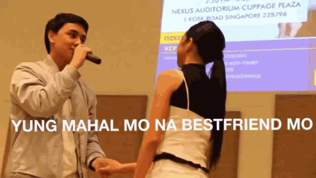 a man singing into a microphone next to a woman with the words " yung mahal mo na bestfriend mo " on the bottom