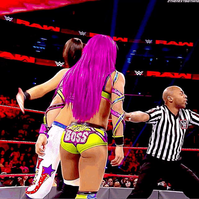 a female wrestler with purple hair has the word boss on her short