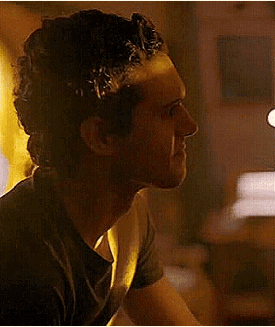 a close up of a man and woman looking at each other in a dark room .