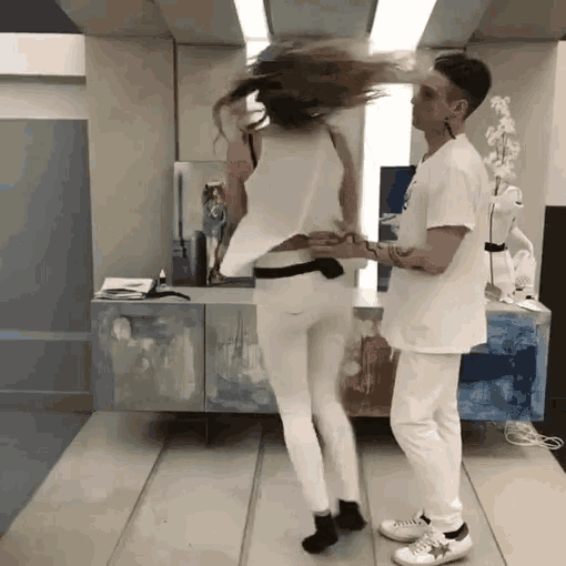 a man and woman are dancing together in a room