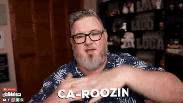 a man with glasses and a beard says ca-roozin with his hands