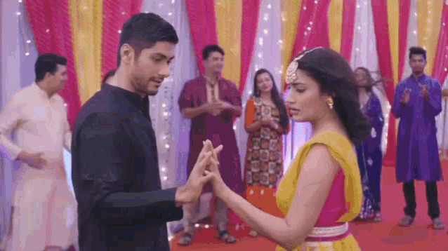 a man and a woman are dancing together in front of a group of people .