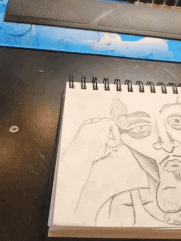 a drawing of a man covering his face with his hand in a spiral notebook
