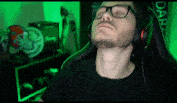 a man wearing headphones and glasses is sitting in a chair with his eyes closed