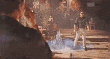 a man in a black shirt and white pants stands in a room with chinese characters on the wall