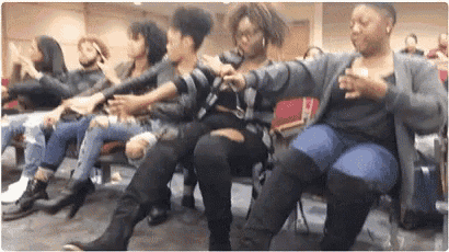 a group of people are sitting in chairs in a room .