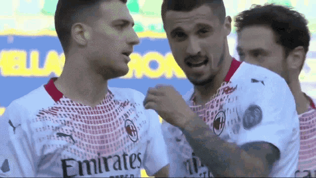 a group of soccer players wearing emirates jerseys are standing together
