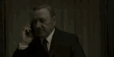 a man in a suit and tie is talking on a cell phone with the words do fuck yourself written on it