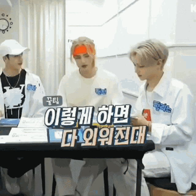 a group of young men are sitting around a table with a sign that says ' korean ' on it .