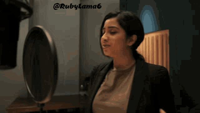 a woman stands in front of a microphone with rubylama6 written on the bottom