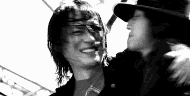 a couple of men are hugging each other in a black and white photo .