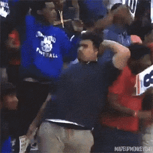 a man in a red shirt is kneeling down in the crowd