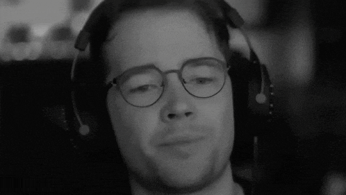 a black and white photo of a man wearing glasses and headphones