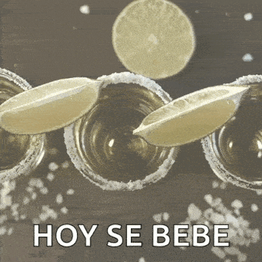 a row of shot glasses with slices of lime and the words hoy se bebe below