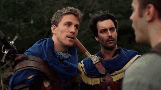 a man holding a sword is talking to another man