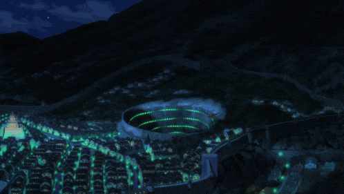an aerial view of a city at night with a large building in the middle