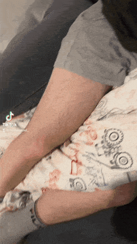 a tiktok video of a person laying on a bed with a floral blanket