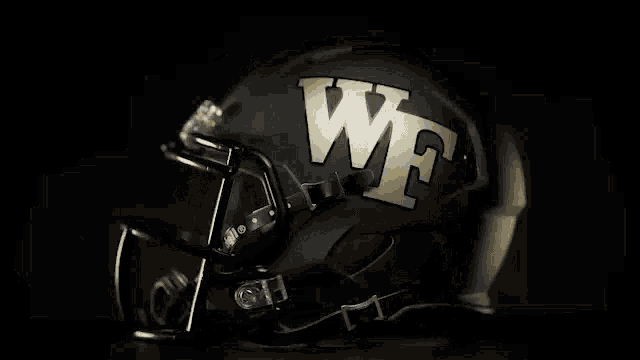 a close up of a black and gold football helmet with the word we on it .