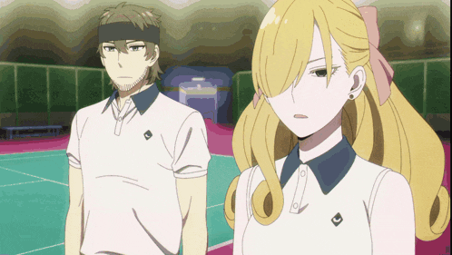 a man and a woman are standing on a tennis court and the man has a headband on his head