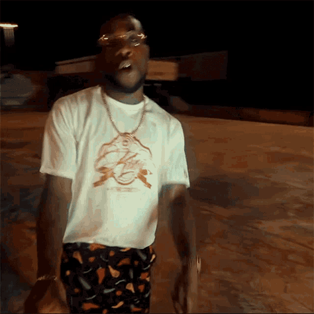 a man wearing a white t-shirt with a picture of a shark on it