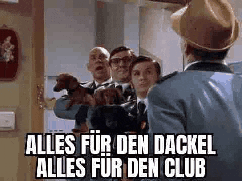 a group of men standing next to each other holding dachshunds and a police officer .