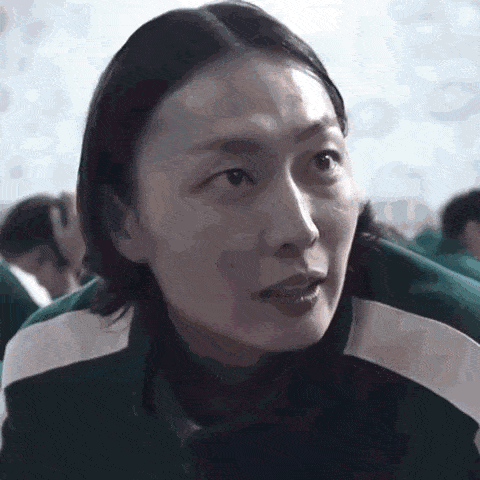 a close up of a woman 's face in a classroom with a group of people behind her .