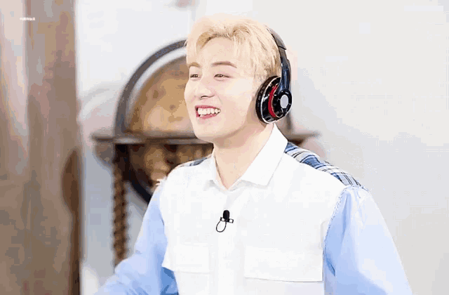 a man wearing headphones and a microphone smiles for the camera