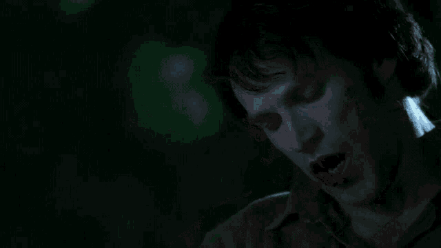 a man with blood coming out of his mouth looks down